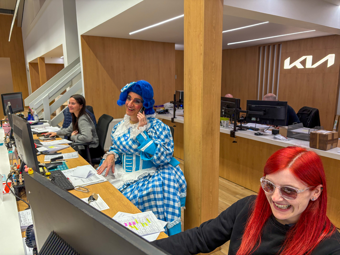 Dame Moira sits on the reception desk of Dicksons, answering a call