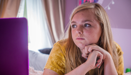 Image of a young girl staring at a computer screen